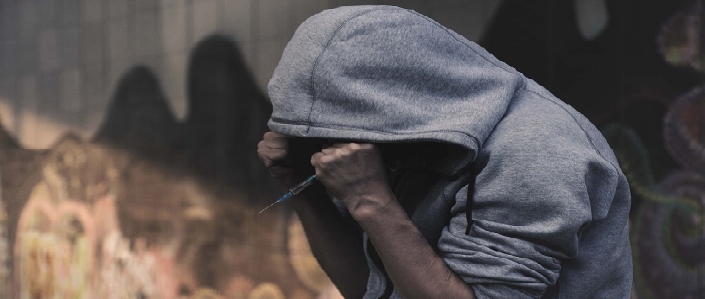 man wearing jacket holding syringe
